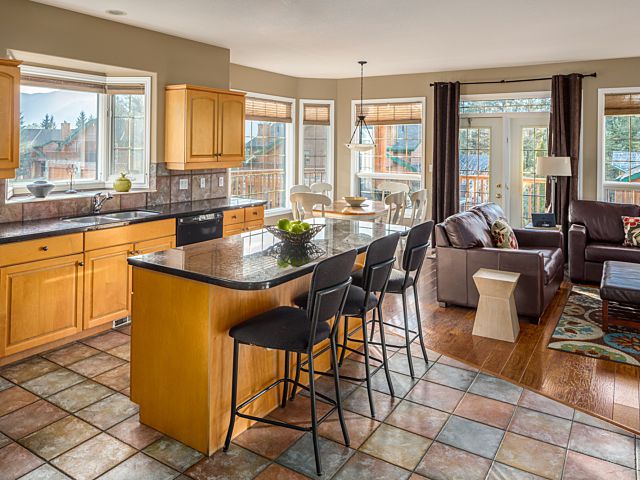 Spacious kitchen with island, barstools, and living space to the rear.