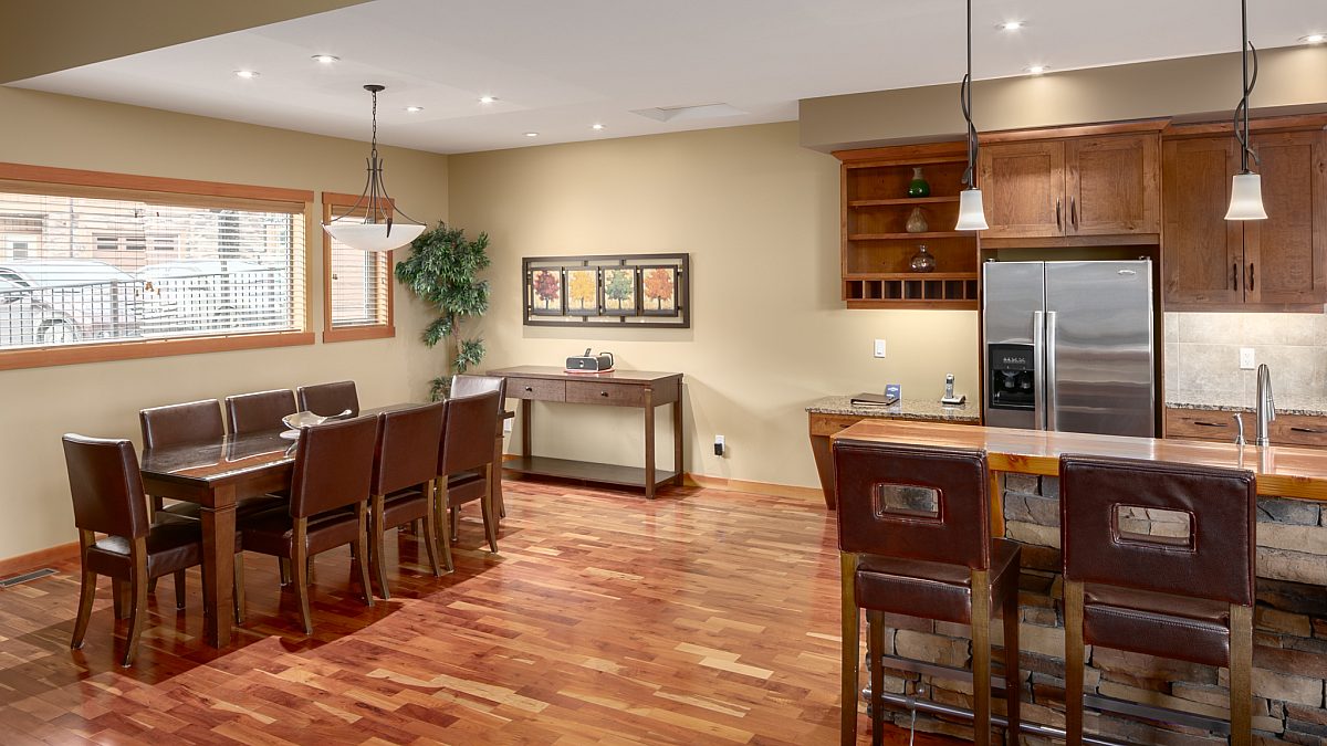 Kitchen and dining areas. Large dining room table and kitchen area with island, barstool and appliances.