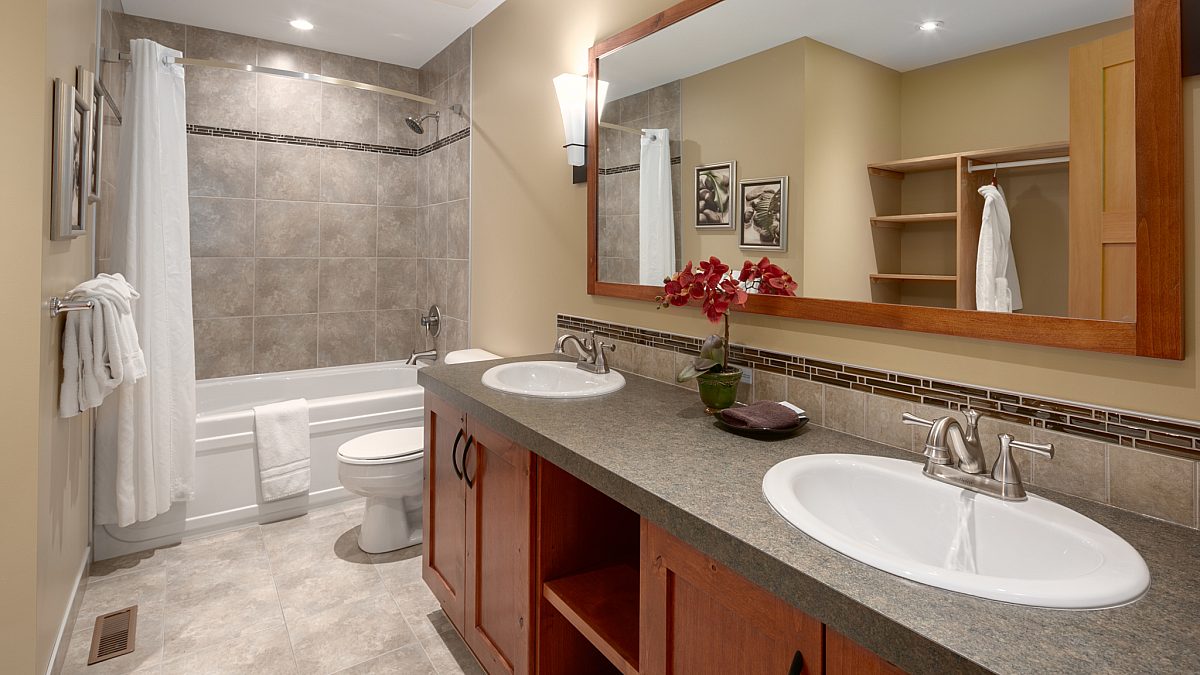 Ensuite bathroom with double sinks, large shower to the left, and vanity.