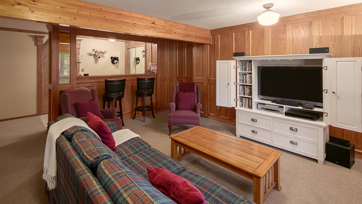 Living space and recreation area. Couch, television, and bar seating.