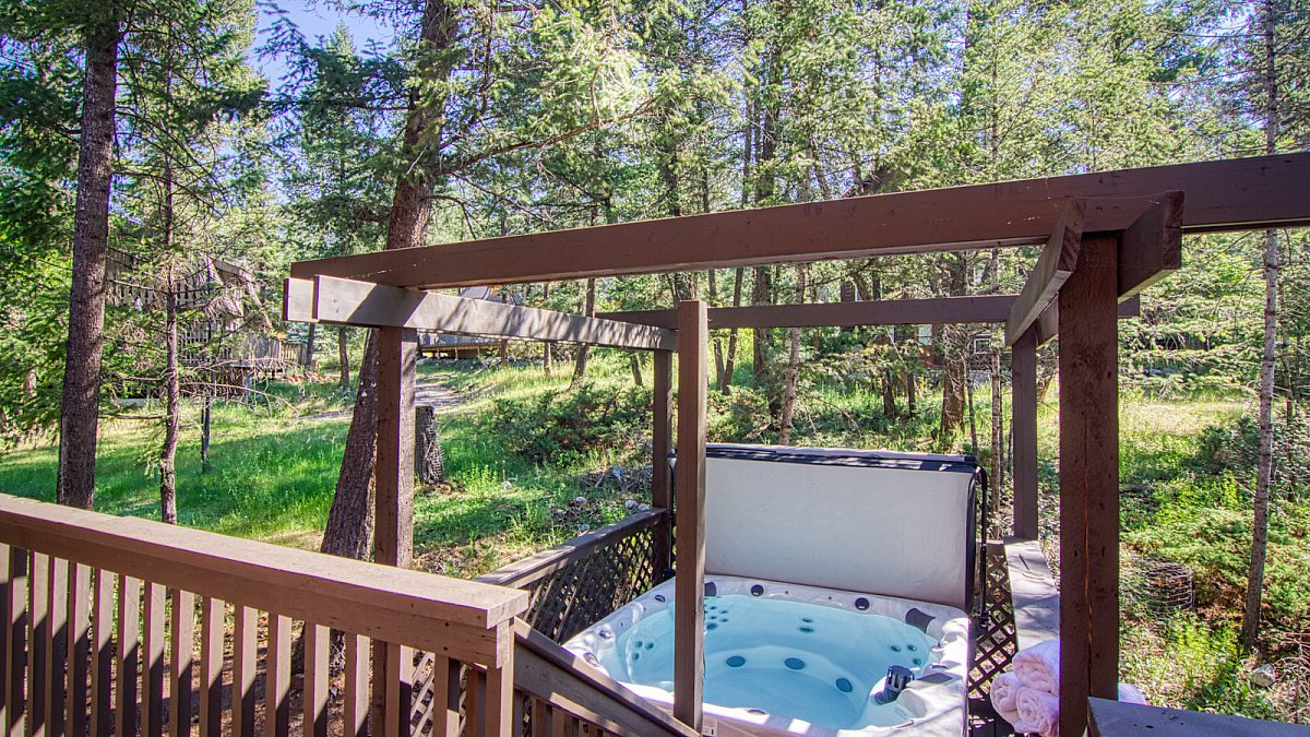 Hot tub with gazebo. Forest and trees in background.