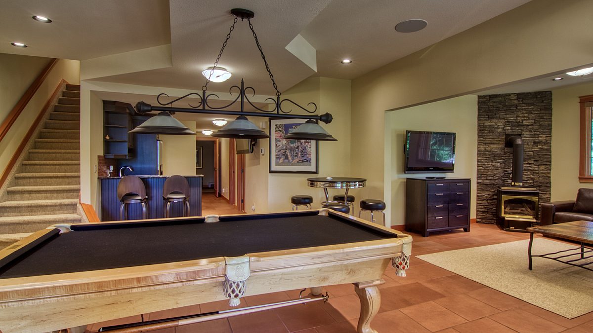 Living area with pool table, television, and fireplace.
