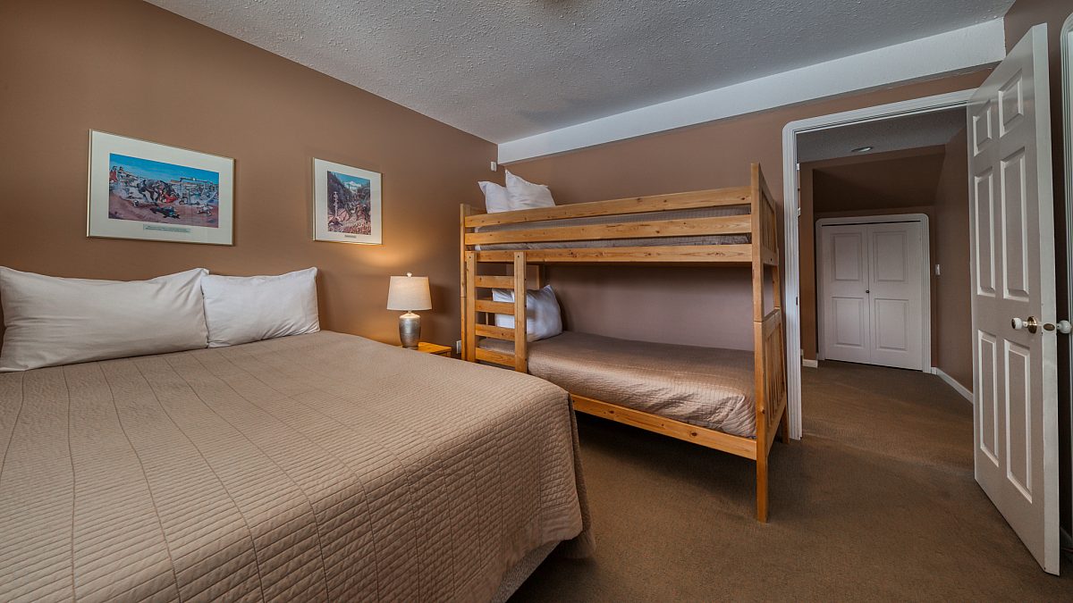 Lower level room with double bed and bunk bed.