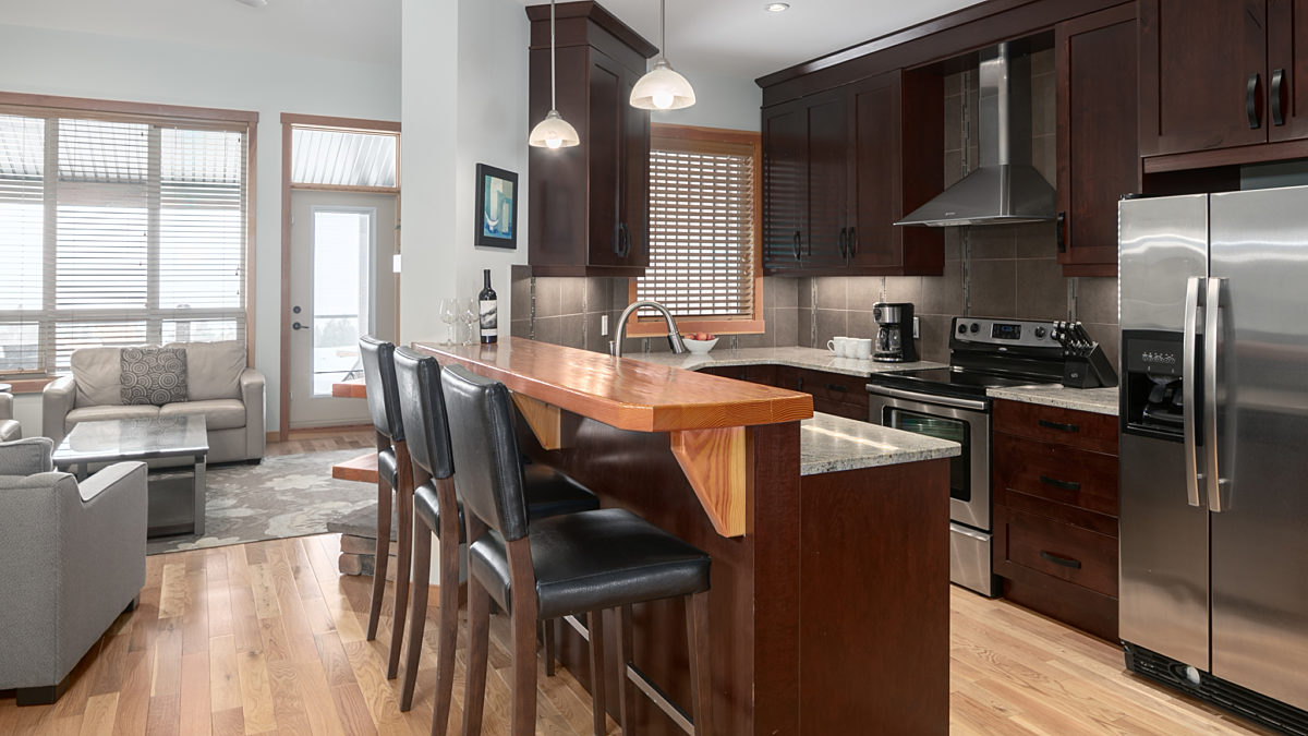 Spacious kitchen with island, barstools, and modern appliances.